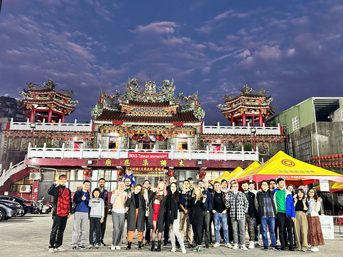 IMAS teachers and students take a group photo in front of the temple