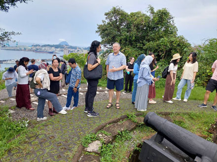 IMAS students and Asian Summer School participants overlooking Keelung Harbor in front of an old cannon at Ershawan Battery.