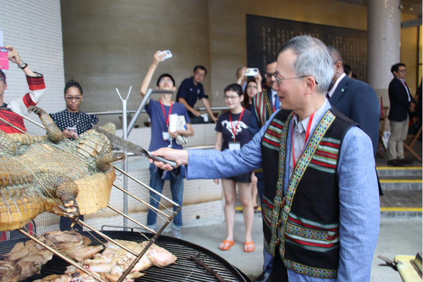 NCCU President Tsai-Yen Li making the first cut on the roasted crocodile.