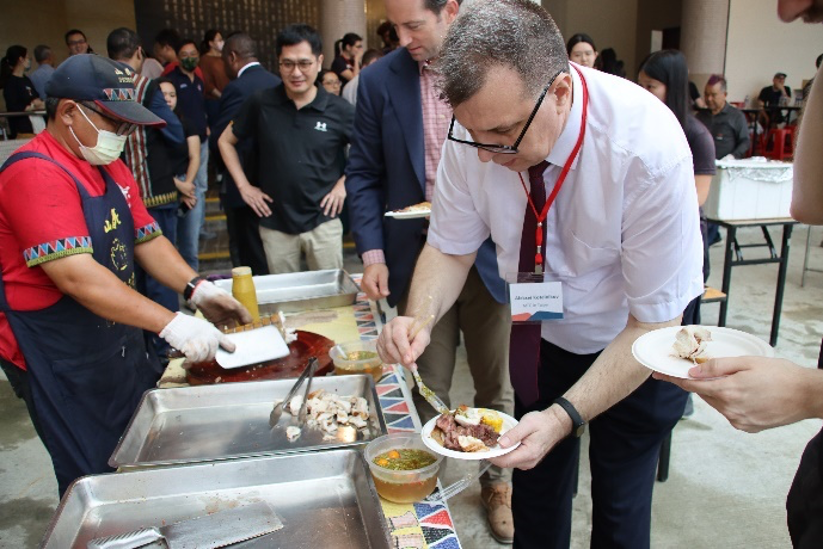 Russian Deputy Representative Aleksei Kotelnikov helping himself to a serving of vegetables; U.S. Army Major Thomas Spencer is in-line behind him.