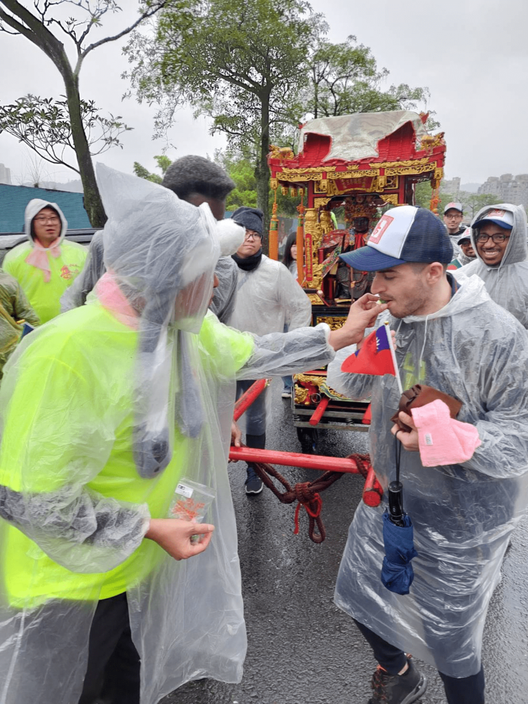 Other parade attendees offer Taiwan-style chewing gum, betel nuts, to Oljan Hallidri.