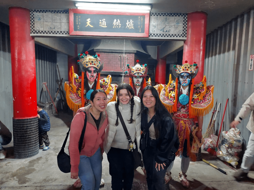 IMAS students Janina Tan, Jaden Gloden and Angela Glowacki are assembled with the Eight General Gods in front of the temple.