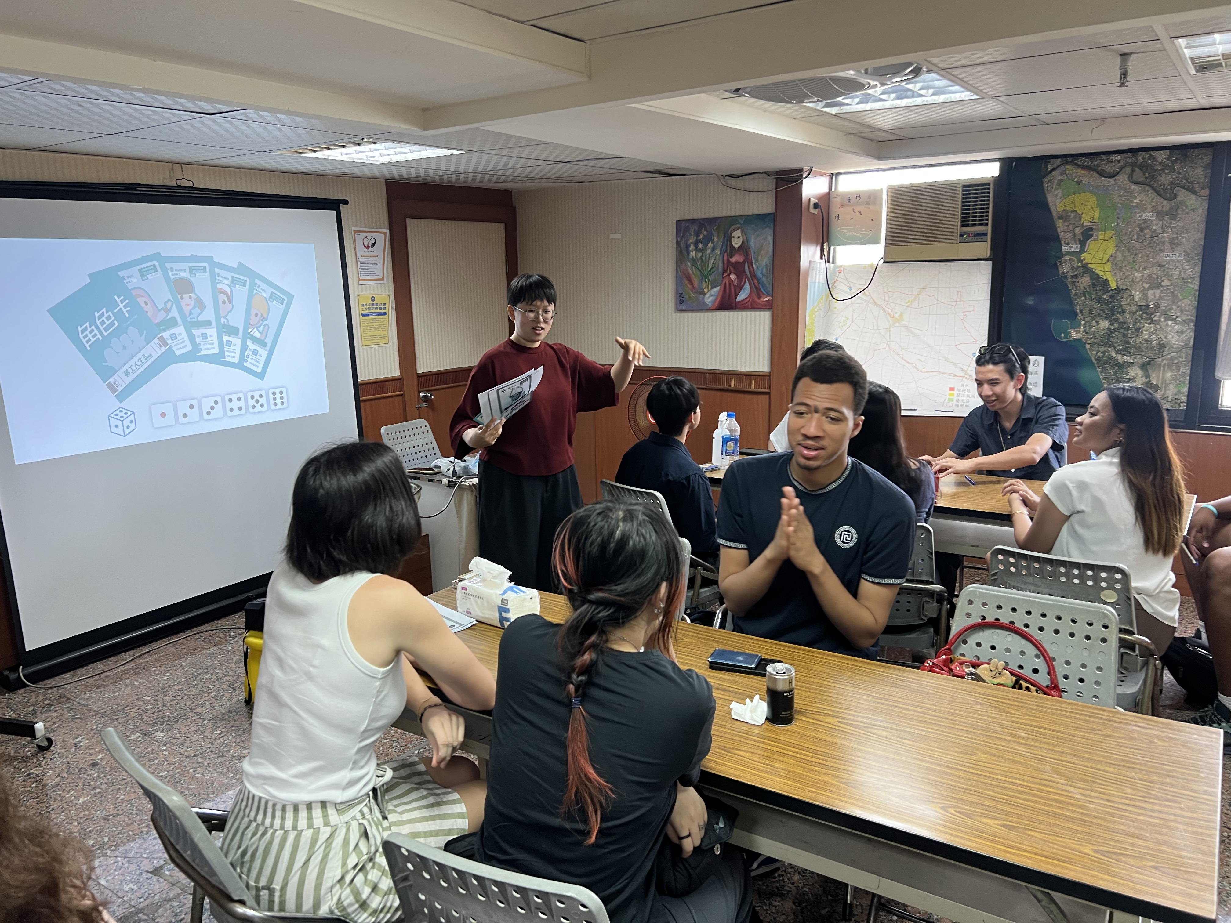 Annie explain the role-playing board game “Migrant Workers’ Life” (移工人生), developed by 1095 Cultural Studio.